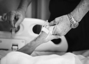 Volunteer holding the hand of a hospital patient
