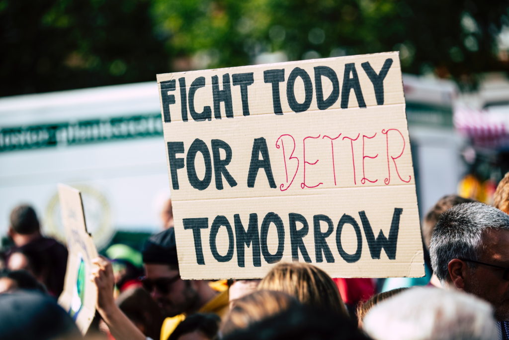 Cardboard placard at a protest with the slogan "Fight today for a better tomorrow"