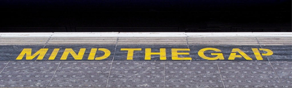 Mind the gap warning painted on a railway station platform