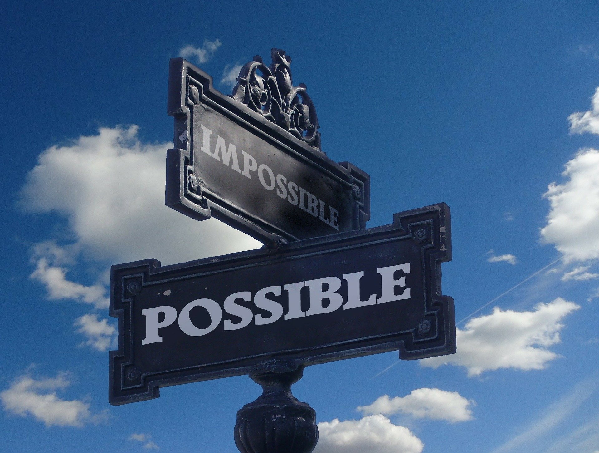 Crossroads signpost with signs saying "possible" and "impossible"