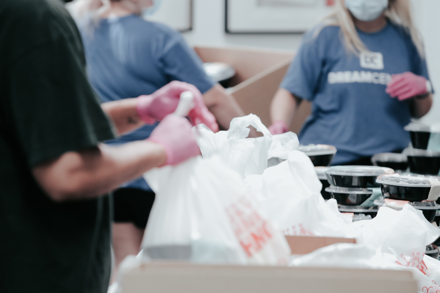 People packing plastic bags of food at a food bank