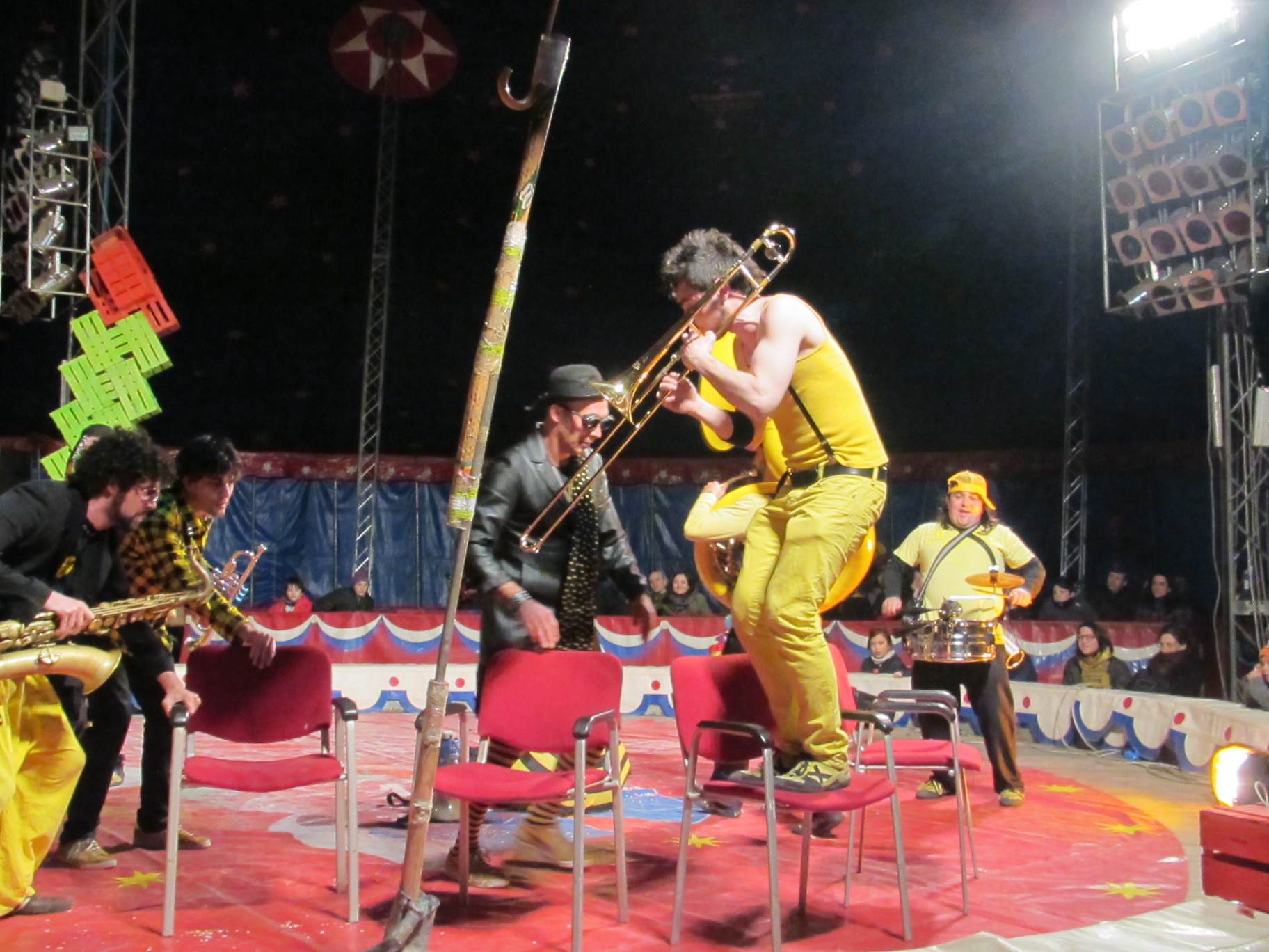 Musicians playing musical chairs in a circus ring